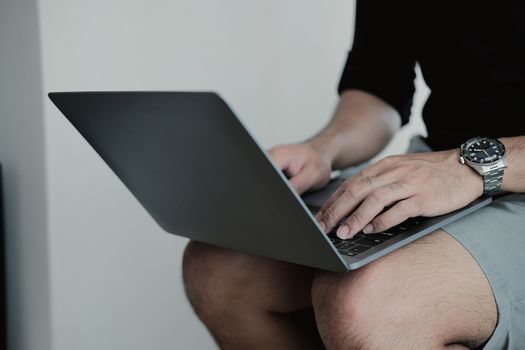 Close up man using smart laptop at home.