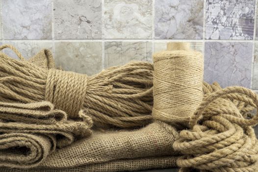 Assorted balls of jute twine, sackcloth fabric and string with skeins of rope in a close up rustic still life