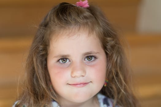 Closeup portrait of happy cute little girl with curly golden hair