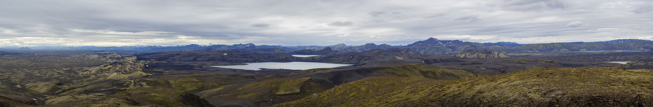 Colorful wide panorama, panoramic view on Volcanic landscape in Lakagigar, Laki Volcano crater chain with green lichens, moss and lakes Kambavatn and Lambavatn, Iceland, moody sky background