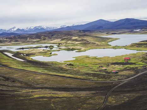 veidivotn fishing hut and cabin, landscape with Colorful crater lake and volcanic snow covered mountains in Veidivotn lakes, popular fishing area for local, central Iceland highlands in the middle of black lava desert