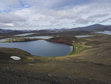 view on landscape with Colorful crater lake and volcanic snow covered mountains in Veidivotn lakes, popular fishing area for local, central Iceland highlands in the middle of black lava desert