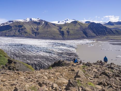 View on glacier lagoon with icebergs and tongue of Skaftafellsjokull, Vatnajokull spur, valley Morsardalur river and colorful rhyolit mountains in Skaftafell national park, Iceland