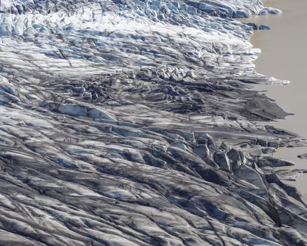 Colorful group of tourist people on glacier walk at tongue of Skaftafellsjokull glacier, Vatnajokull spur, in Skaftafell national park, Iceland