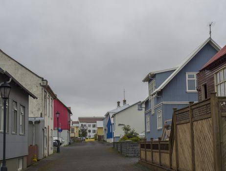 side street with old houses and street lamps in Keflevik town, Iceland, moody sky