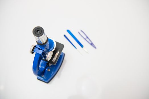 microscope on a white background with research tools with copy space