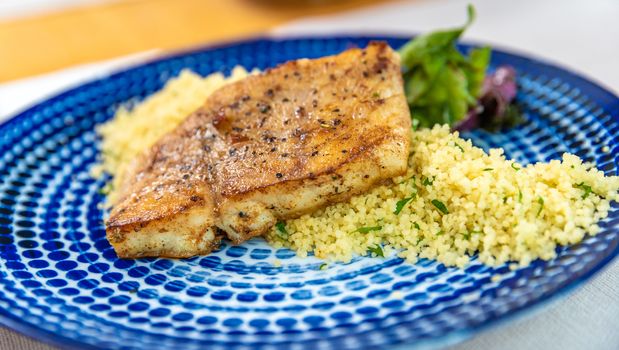 Roast pork with couscous on a plate.