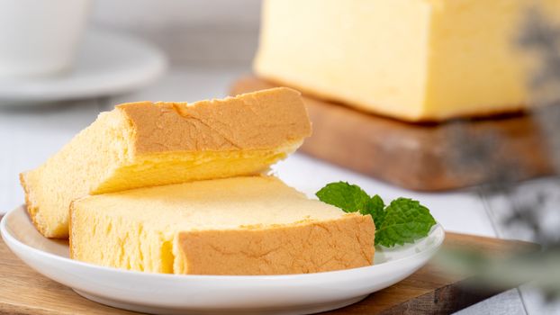 Plain classic Taiwanese traditional sponge cake (Taiwanese castella kasutera) on a wooden tray background table with ingredients, close up.