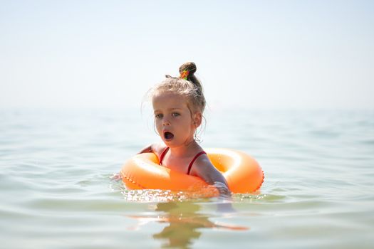Child swims sea inflatable ring. danger of drowning Safety equipment, Child Life buoy Little Caucasian girl have fun in sea water Summer vacation active leisure. Lifestyle