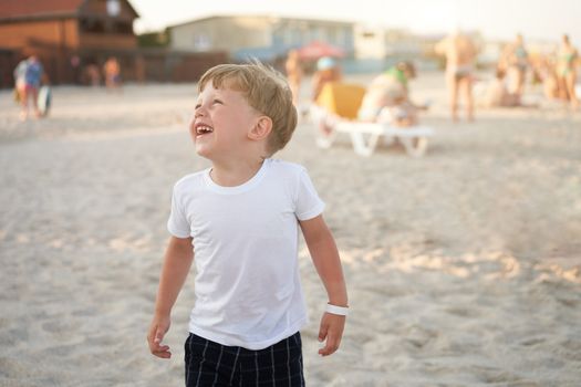 Caucasian boy standing beach. Childhood summertime. Family vacation with one child.