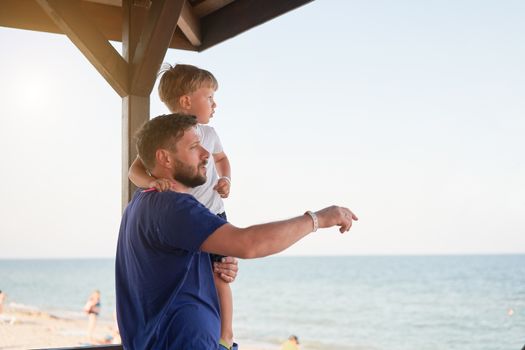 Father son together outside showing finger sea horizon back Man child spending time vacation enjoying summer Family with one child. Caucasian person beach