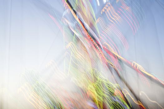 Amusement park blurred effect. Abstract illuminated background Spinning defocused carnival carousel long exposure shooting