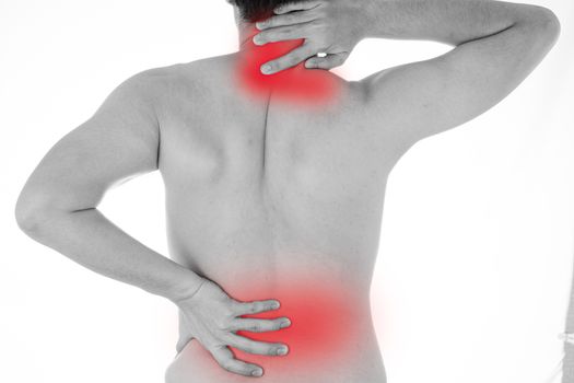 Black and white shot of man feeling exhausted and suffering from neck and back pain and injury on isolated white background with red spot. Health care and medical concept.