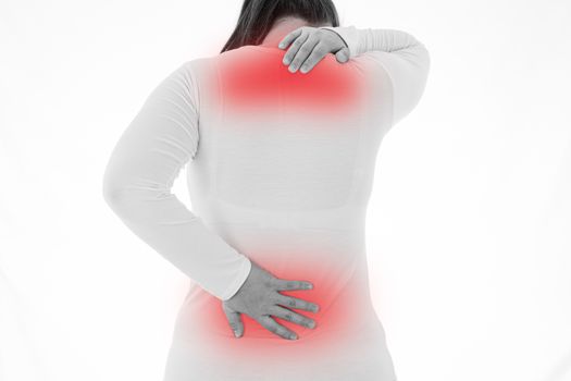 Black and white shot of woman feeling exhausted and suffering from neck and back pain and injury on isolated white background with red spot. Health care and medical concept.