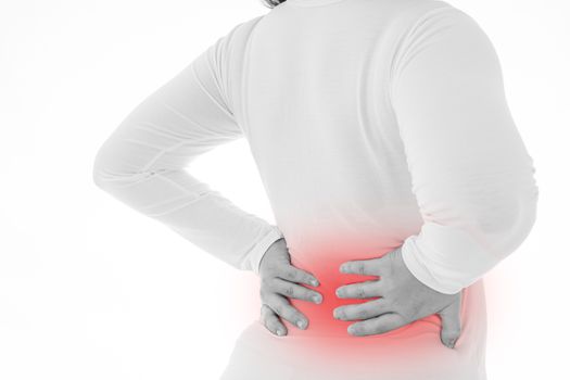 Black and white shot of woman feeling exhausted and suffering from waist and back pain and injury on isolated white background with red spot. Health care and medical concept.