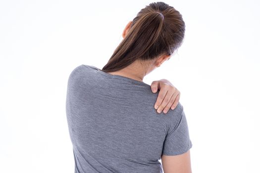 A woman feeling exhausted and suffering from shoulder and neck pain and injury on isolated white background. Health care and medical concept.