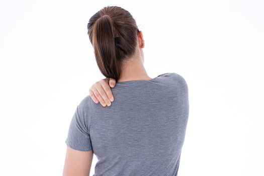 A woman feeling exhausted and suffering from shoulder and neck pain and injury on isolated white background. Health care and medical concept.