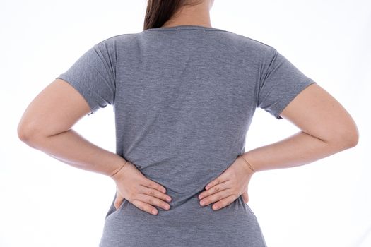 A woman feeling exhausted and suffering from waist and back pain and injury on isolated white background. Health care and medical concept.