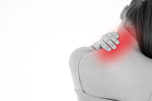 Black and white shot of woman feeling exhausted and suffering from shoulder and neck pain and injury on isolated white background with red spot. Health care and medical concept.