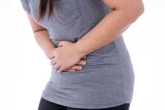 A woman feeling exhausted and suffering from stomach pain and injury on isolated white background. Health care and medical concept.