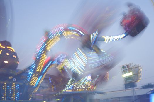 Amusement park blurred effect. Abstract illuminated background Spinning defocused carnival carousel long exposure shooting