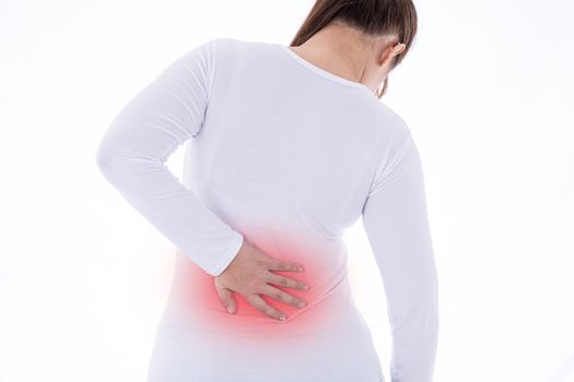 A woman feeling exhausted and suffering from waist and back pain and injury on isolated white background with red spot. Health care and medical concept.