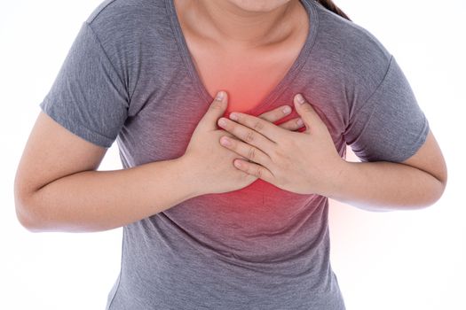 A woman feeling exhausted and suffering from heart pain and injury on isolated white background with red spot. Health care and medical concept.