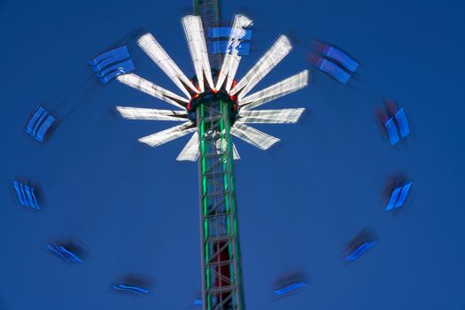 Amusement park blurred effect. Abstract illuminated background Spinning defocused carnival carousel long exposure shooting