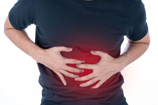A man feeling exhausted and suffering from stomach pain and injury on isolated white background with red spot. Health care and medical concept.