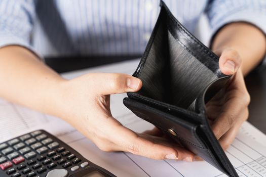 Poor Asian woman hand open empty wallet looking for money having problem bankrupt broke after credit card payday. Insolvency in the economy and finance. People have no money.