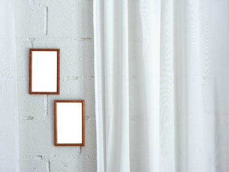 White blank space on two wooden frames on white brick wall and white soft curtain background with copy space.