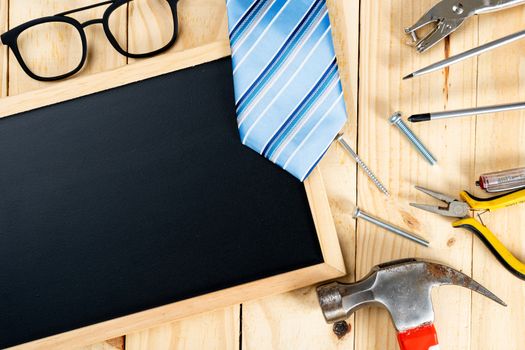 Happy Father Day background concept with tools, blackboard and tie on wooden background with copy space for text.