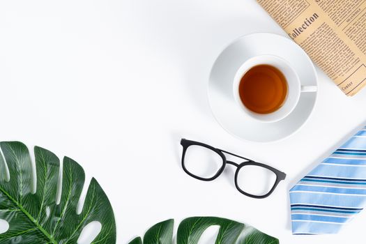 Happy Father Day background concept with blue necktie, glasses, cup of tea, newspaper and leaf on white background with copy space for text.