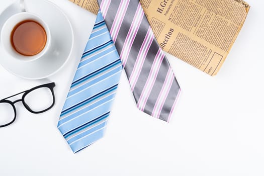 Happy Father Day background concept with blue and pink necktie, cup of tea and glasses on white background with copy space for text.