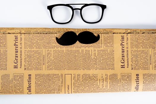 Happy Father Day background concept with glasses, newspaper and black mustache on white background with copy space for text.