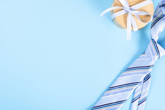 Happy Father Day background concept with blue necktie and gift box on blue background with copy space for text.