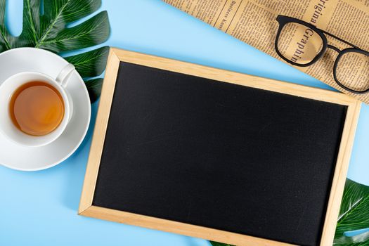 Happy Father Day background concept with leaf, cup of tea, glasses, blackboard and newspaper on blue background with copy space for text.