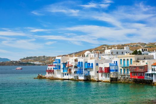 Scenic Little Venice houses in Chora Mykonos town with yacht and cruise ship. Mykonos island, Greecer