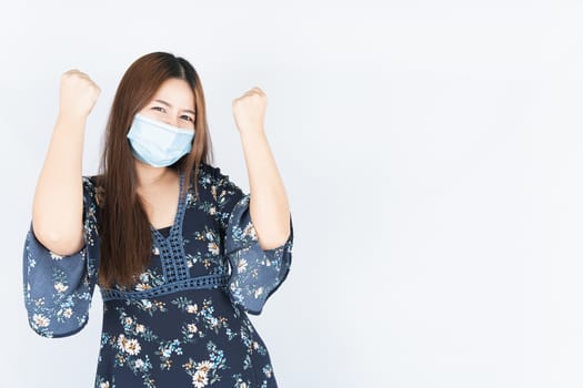 Asian beautiful happy hipster woman wearing a medical protection face mask for protect the coronavirus, filter dust PM 2.5 and cold and raise her hand to fight them on white background