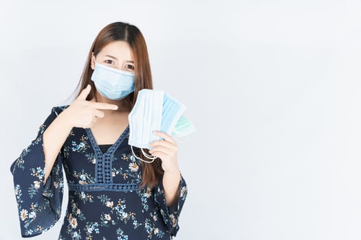 Asian beautiful happy hipster woman showing a medical protection face mask for protect the coronavirus, filter dust PM 2.5 and cold on the white background