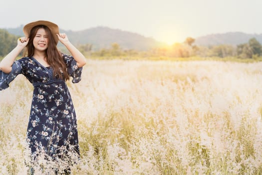 Summer portrait of young hipster woman standing in meadow on sunny day.young slim beautiful woman, bohemian outfit, indie style, summer vacation, sunny, having fun, positive mood, romantic, woman in hat