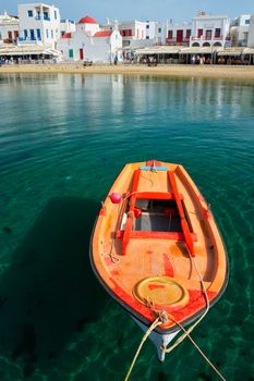 Greek fishing boat in clear sea water in port of Mykonos. Chora town, Mykonos, Greece