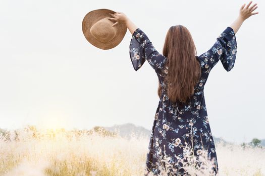 Summer portrait of young hipster woman standing in meadow on sunny day.young slim beautiful woman, bohemian outfit, indie style, summer vacation, sunny, having fun, positive mood, romantic, woman in hat