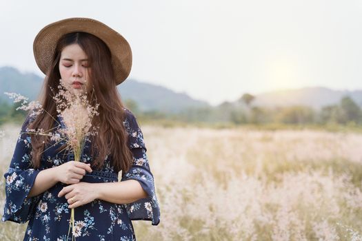 Summer portrait of young hipster woman standing in meadow on sunny day.young slim beautiful woman, bohemian outfit, indie style, summer vacation, sunny, having fun, positive mood, romantic, woman in hat