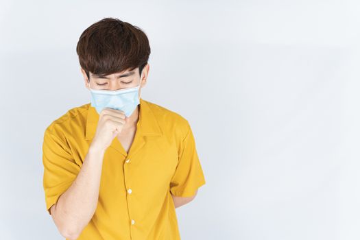 Asian handsome happy hipster man wearing a medical protection face mask for protect the coronavirus, filter dust PM 2.5 and cold and she coughing to mask on white background