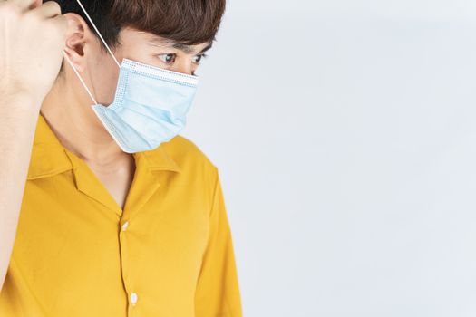 Asian handsome happy hipster man wearing a medical protection face mask for protect the coronavirus, filter dust PM 2.5 and cold on white background