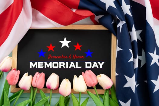 US American flag with blackboard and tulip flower on blue wooden background. For USA Memorial day. Top view with memorial day text.