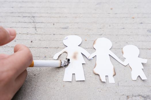 Paper cut of family members destroyed by cigarette. Smoking destroying family concept. Quit smoking for life on world tobacco day.