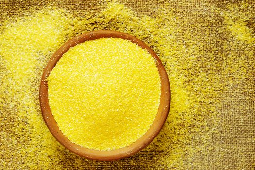 Yellow grains of cornmeal  on bowl  ,it’s a common staple food  of Northen Italian called polenta