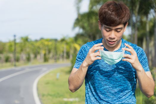 Young male wearing medical mask before workout training session at the park. Stay in fit during quarantine in the days of the Corona Virus or Covid-19